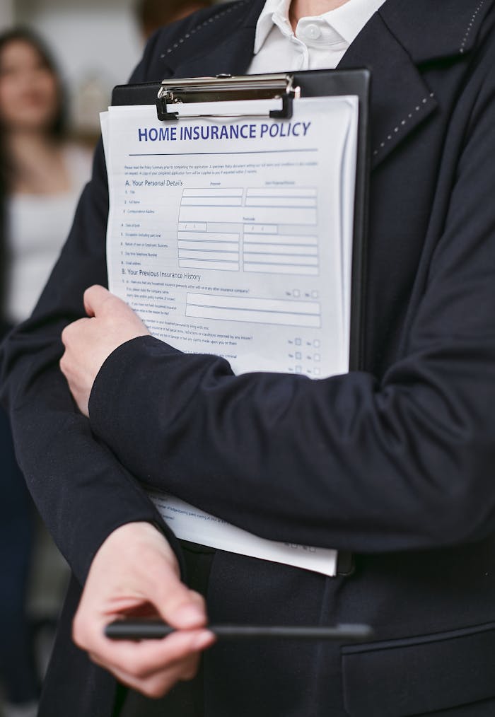 services-img Close-up of a person holding a home insurance policy on a clipboard indoors.